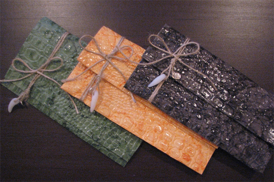 Конверты из дизайнерской бумаги и веревочными завязками, украшенными подвесками